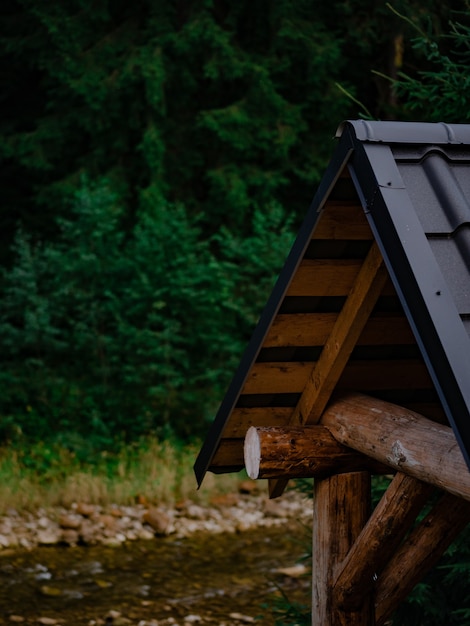 Wooden gazebo against the background of the river and forest