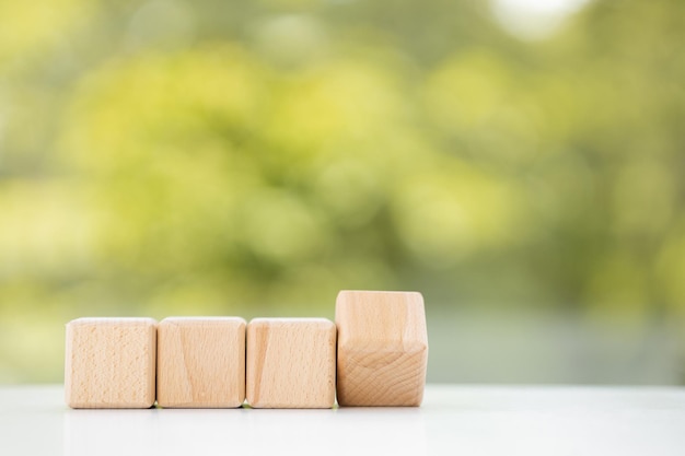 Wooden geometric shapes cubes isolated on a green summer background