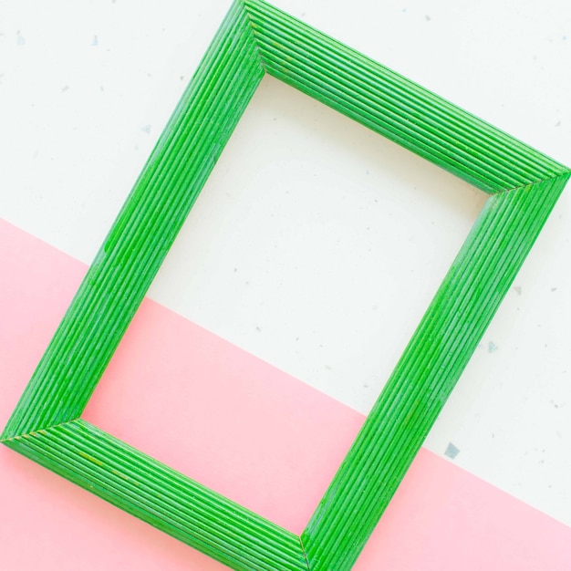 Wooden green photo frame on white and pink background