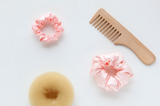 wooden hairbrush barrette and silk pink scrunchy flat lay elastic hair bands scrunchie hairband