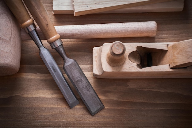 Wooden hammer planner chisels building planks on wood board construction concept.