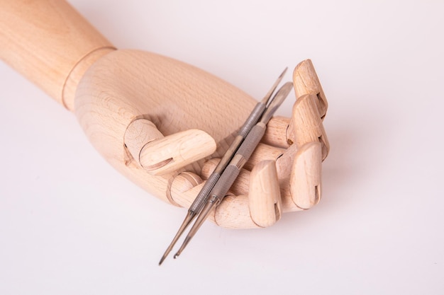 Wooden hand holding nail instruments