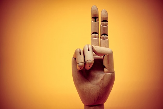 Wooden hand pointing up 2 fingers