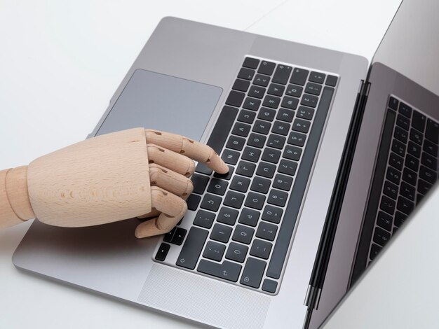 Wooden hand touching computer keyboard