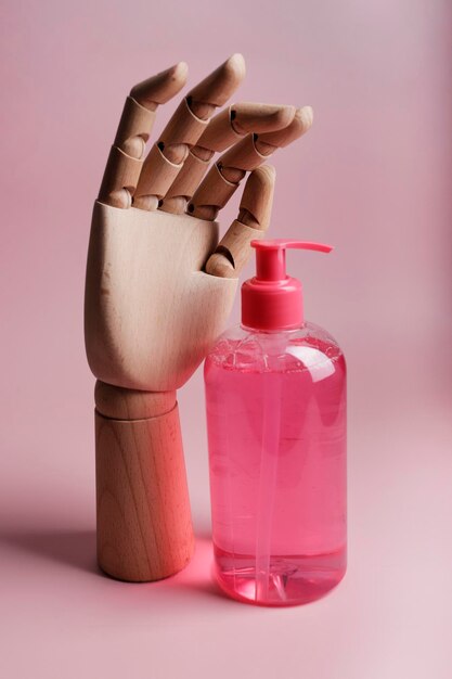 wooden hand with hand soap in pink color