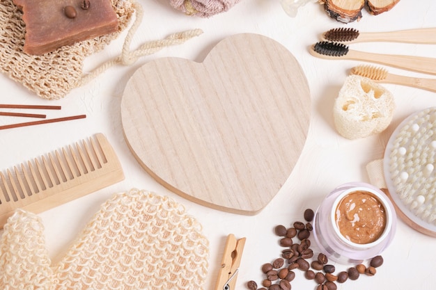 Wooden heart and eco friendly hygiene products set for care and hygiene, bathroom accessories made from natural materials on a beige background, zero waste lifestyle