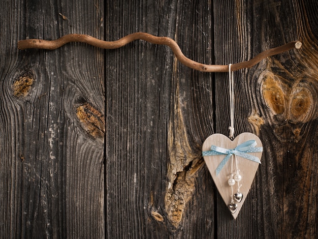 Photo wooden heart hanging on a branch