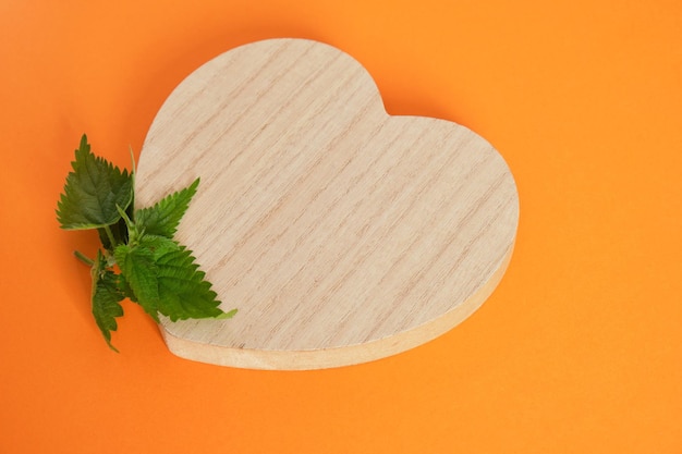 Wooden heart shaped podium and nettle leaves