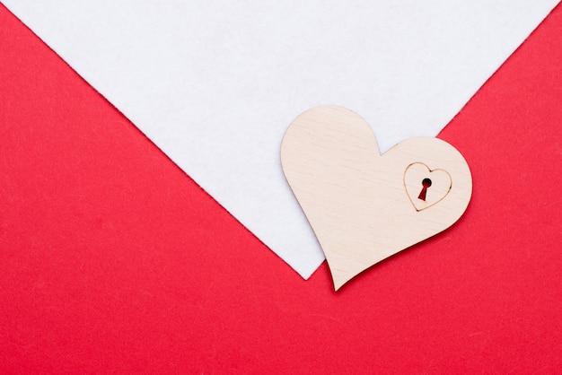 Wooden heart on white and red surface