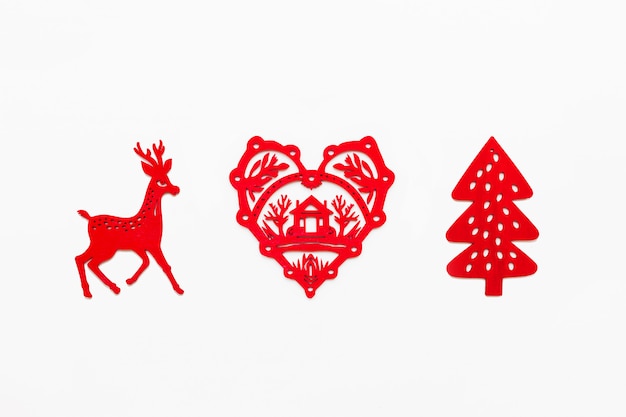 Photo wooden heart with silhouette of house, running deer, fir tree. ornamental red christmas decoration.