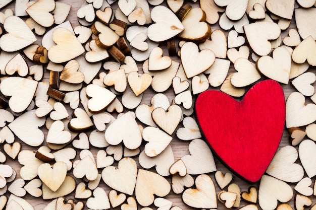 Деревянные сердца, одно красное сердце на сердечном фоне.