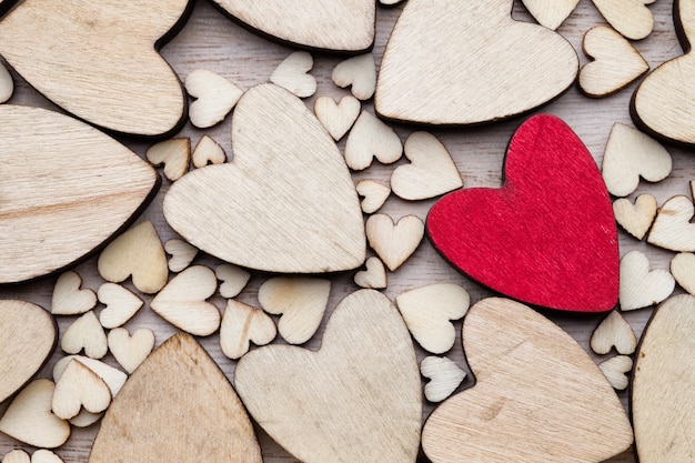 Wooden hearts, one red heart on the heart background.