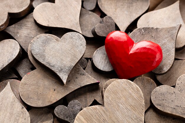 Wooden hearts, one red heart on the heart background.