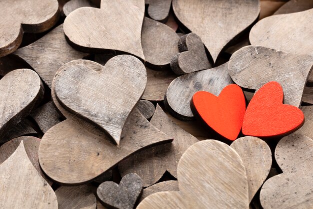 Деревянные сердца, одно красное сердце на сердечном фоне.