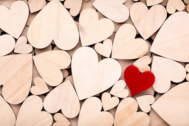 Wooden hearts, one red heart on the wooden heart background.	




