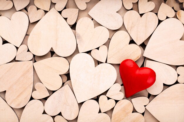 Wooden hearts one red heart on the wooden heart surface