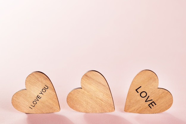 Wooden hearts on pink background