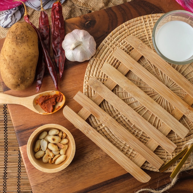 Rilievo di riscaldamento di legno con un bicchiere di latte e un cucchiaio e una forchetta con lo spazio in bianco del testo.