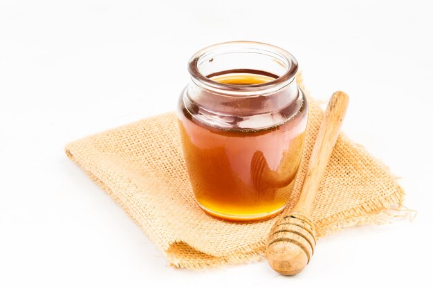 Wooden honey dipper on white background