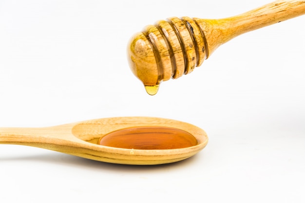 Wooden honey dipper on white background