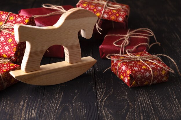 Wooden horse in front of a bunch of presents