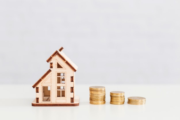 Photo wooden house and coins stack