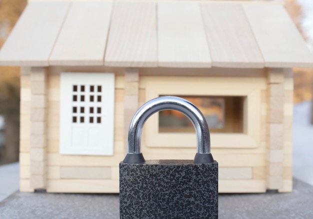 Photo the wooden house is hidden behind a barn lock. real estate protection concept.