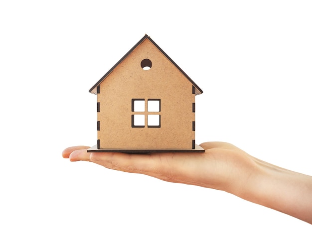 Wooden house in a male hand on a white isolated background