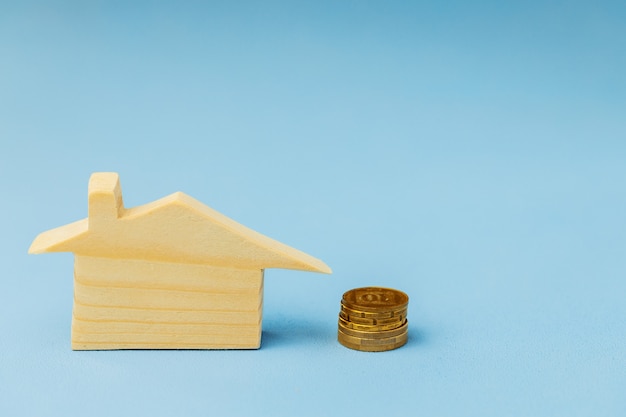 Wooden house miniature on blue background close up photo