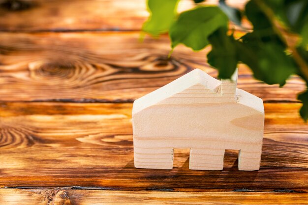 Wooden house miniature on wooden surface close up photo