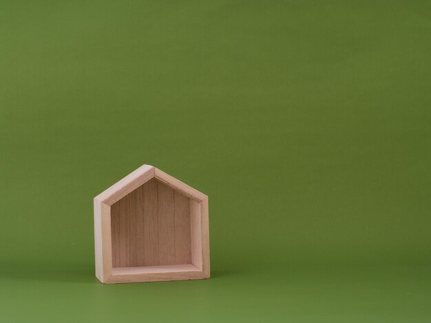 Wooden house model on green background