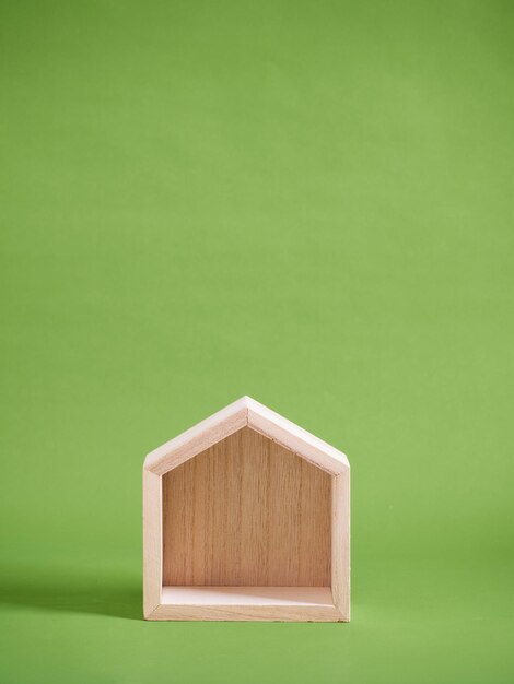 Wooden house model on green background