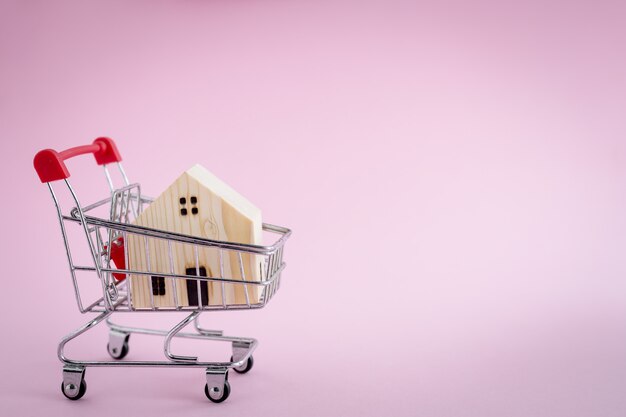 Photo wooden house model in the shopping cart