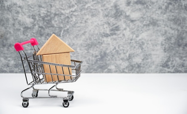 wooden house model in supermarket cart property on sale real estate business house loan