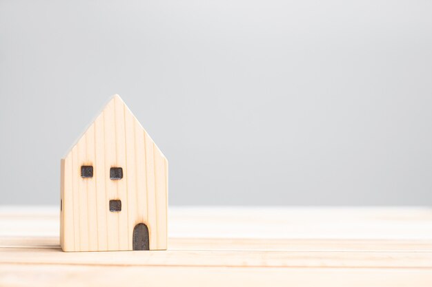 Modello di casa in legno sullo sfondo del tavolo. concetto di casa, crisi, recessione economica, senzatetto, immobiliare, acquisto o affitto e proprietà