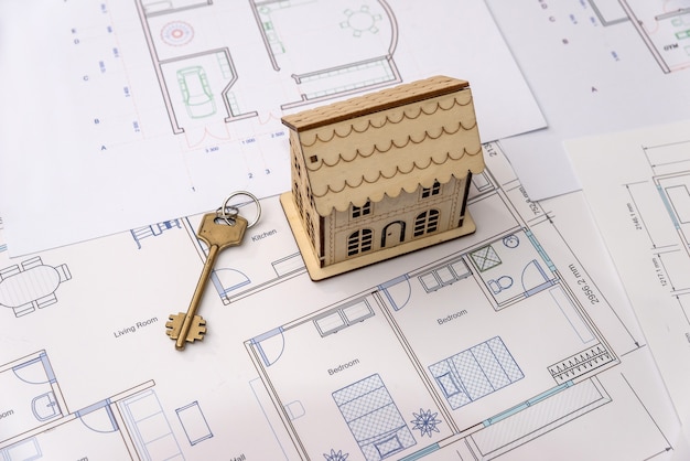 Wooden house model with key on house plan