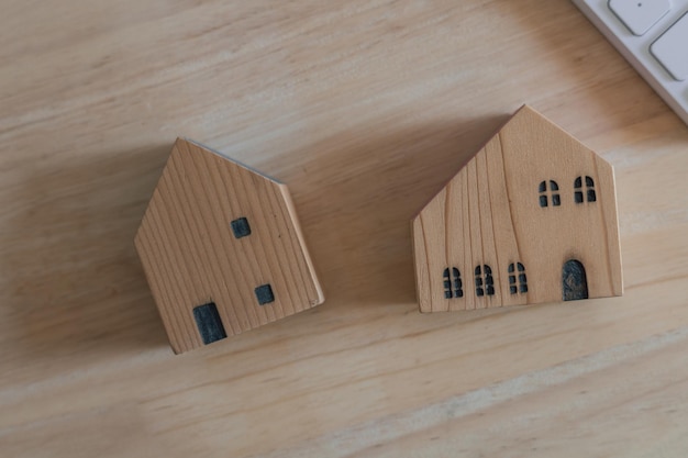 Wooden house model on wooden floor, housing concept