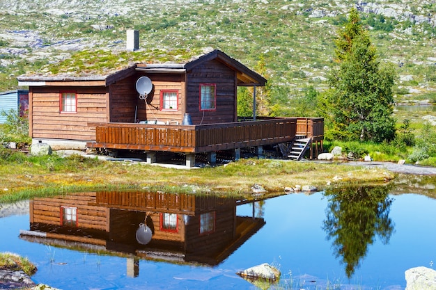 Photo wooden house near small summer mountain lake.