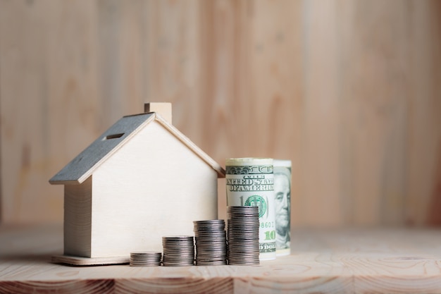 Wooden house piggy bank with dollar money and coin 