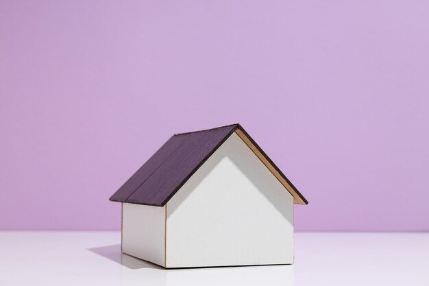 Wooden house on purple background space for text