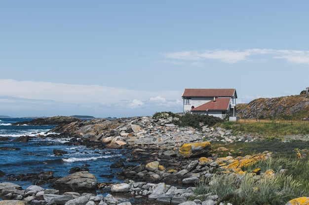 деревянный дом на скалистом берегу на побережье Северного моря в Норвегии
