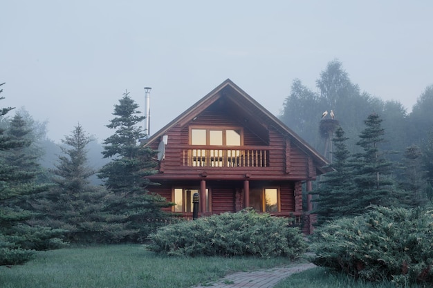 Wooden house among the trees at sunrise in summer