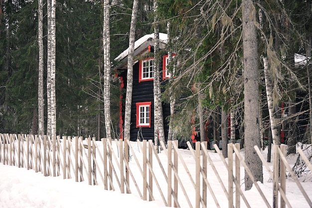 Wooden house in winter forest with wooden