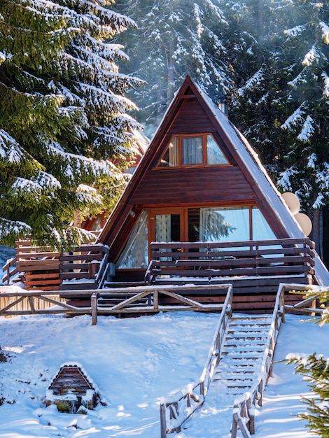 Casa in legno nella foresta invernale