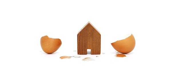 Wooden house with egg shell on white background.