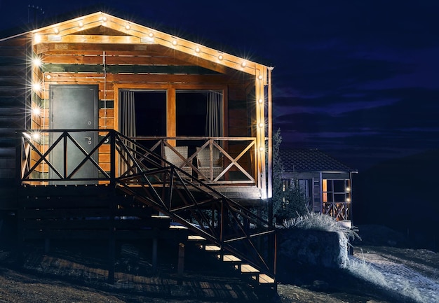 Wooden house with glowing lamps at night