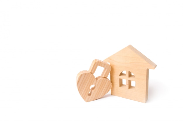 Wooden house with Heart shaped lock on a white background. Love nest, relationships. 