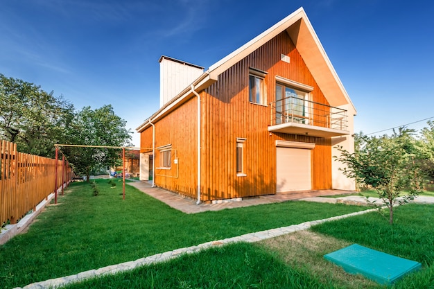 Wooden house with meadow in front of it