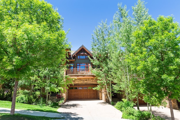 Wooden house with trees around it in sunny day