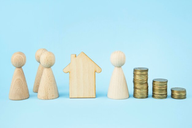 Casa in legno e omini di legno su sfondo blu. divisione di proprietà. concetto di assicurazione, prestiti. copia spazio. bandiera.